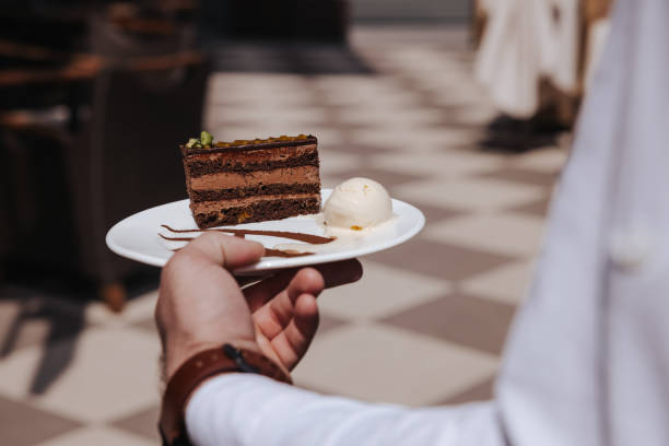 istock Waiter serving chocolate cake in sidewalk cafe 1343639986