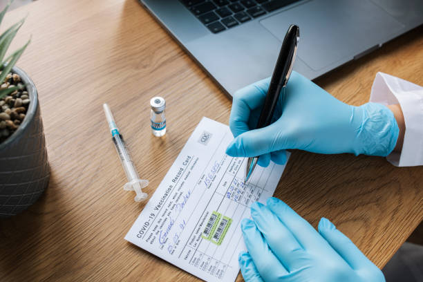 istock Filling Out Second Dose Covid-19 Vaccination On Record Card 1343651289