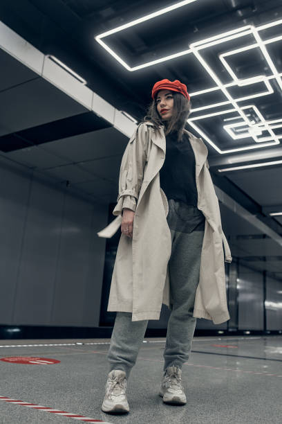 garota em um casaco bege trench no metrô esperando o trem na plataforma - 16715 - fotografias e filmes do acervo