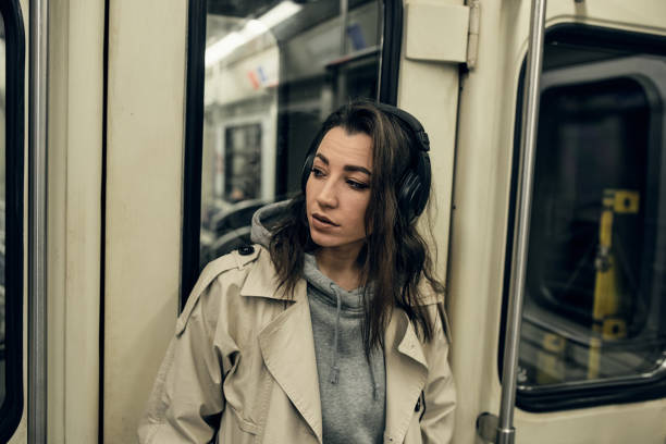 a girl in a beige trench coat rides in a subway car - 16607 imagens e fotografias de stock