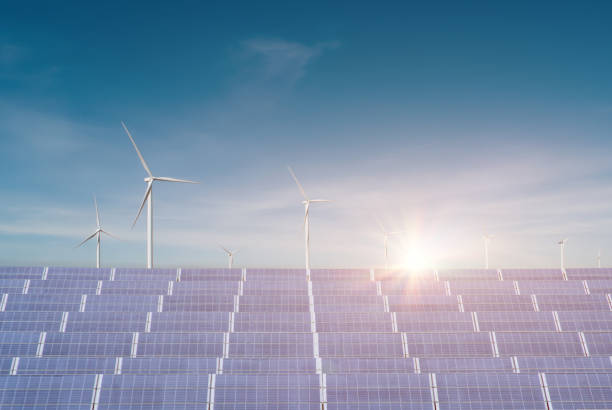 istock Solar panels with wind turbines against blue sky background. 1343665522