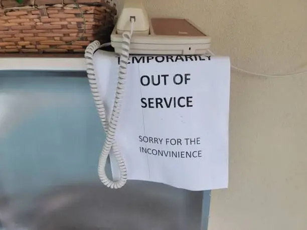 paper out of service sign warning on telephone
