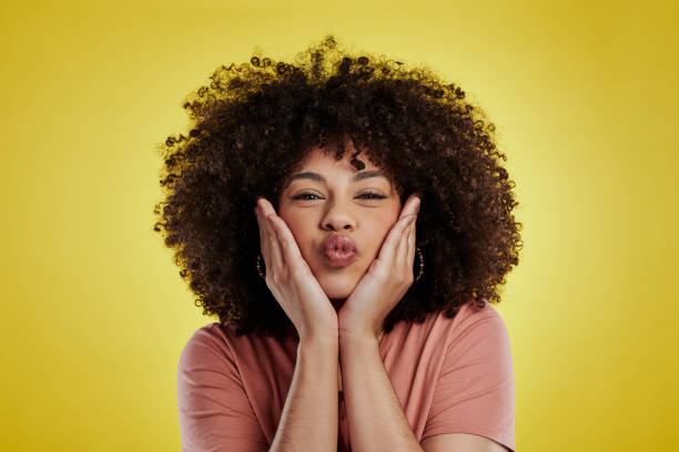 Studio shot of an attractive young woman posing against a yellow background When in doubt, pout it out puckering stock pictures, royalty-free photos & images