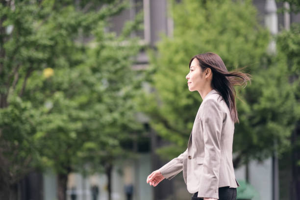 街の通りを歩くビジネスウーマンのサイドビュー - city street street walking tree ストックフォトと画像