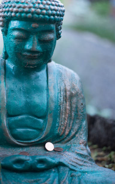 istock Green Buddha Statue with Pennies Close-Up 1343672943