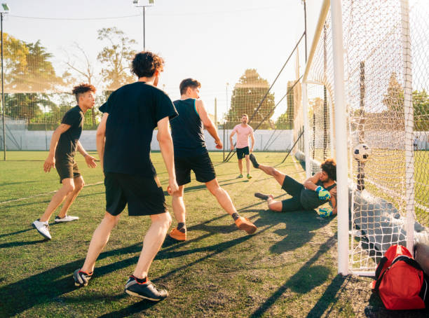 istock Young players scoring goal at soccer field 1343674680