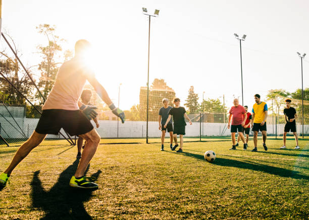 istock Male athletes playing soccer at field 1343674837