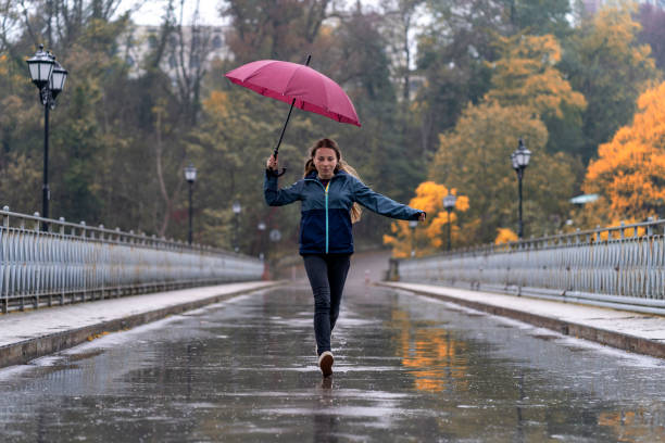 istock Woman withumbrella having fun in rainy day 1343680800