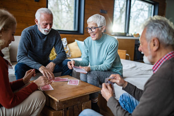 istock Happy senior friends enjoying while playing cards at home. 1343682836