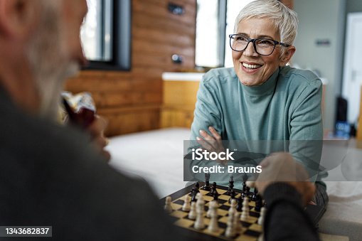 istock Happy mature couple playing chess at home. 1343682837