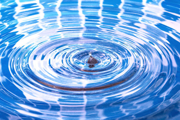 istock Water splash. Falling drop of water in the pool. Circles on the water. 1343687624