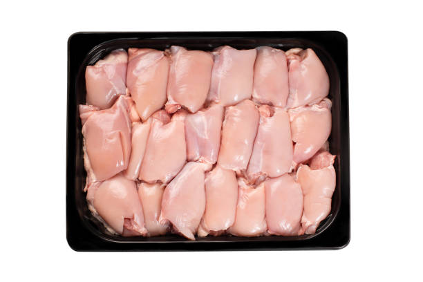 raw chicken thighs boneless skinless in packaging tray.lots of chunks of fresh skinless chicken thigh in a plastic supermarket tray. raw skinless chicken thigh. - chicken thighs imagens e fotografias de stock