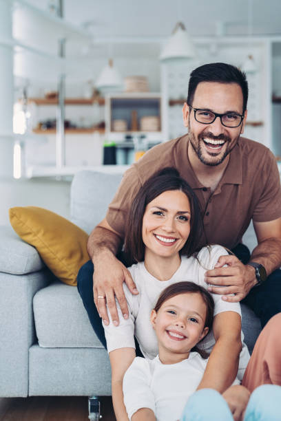 Portrait of a beautiful family with a child at home stock photo