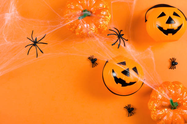 istock Decorations for halloween on an orange background with place for text, flat lay. Pumpkins, cobwebs and spiders on an orange background. Halloween party 1343692148