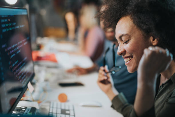 istock Cheerful African American computer programmer celebrating success in the office. 1343692765