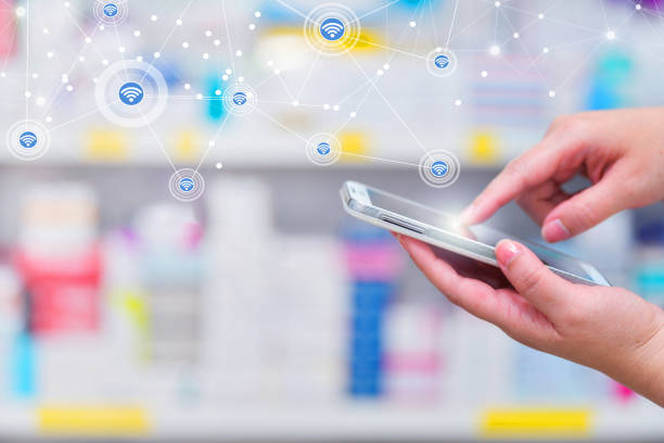 Pharmacist using mobile smart phone for search bar on display in pharmacy stock photo