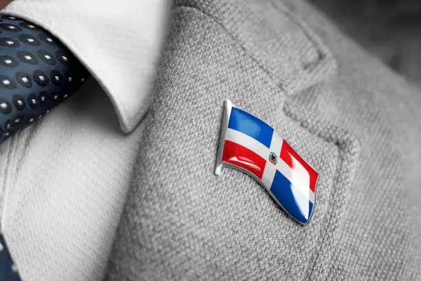 Metal badge with the flag of Dominicana on a suit lapel.