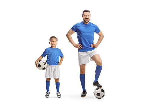 Man and boy with soccer balls wearing same color jersey isolated on white background