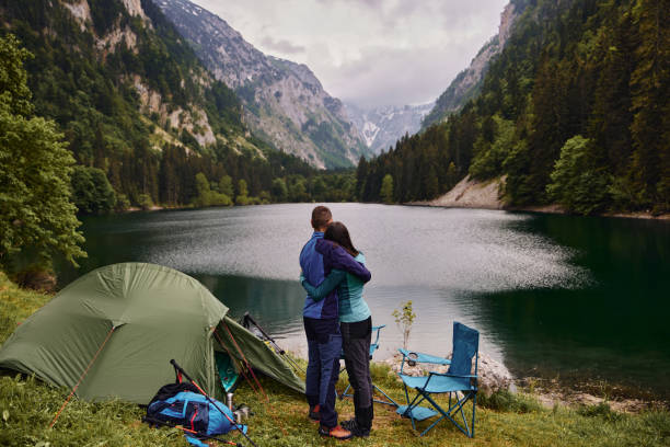 istock Embraced couple relaxing near a lake while camping 1343706586
