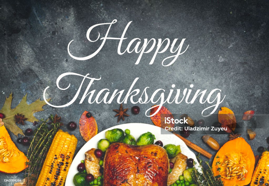 Happy Thanksgiving lettering on a festive dinner background. Food table background with autumn seasonal specialties for Thanksgiving Day. Fried chicken with pumpkin, vegetables and autumn decor Happy Thanksgiving lettering on a festive dinner background. Food table background with autumn seasonal specialties for Thanksgiving Day. Fried chicken with pumpkin, vegetables and autumn decor. High quality photo Thanksgiving - Holiday Stock Photo