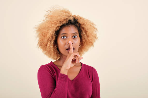 istock Surprised afro woman making a silence or secret gesture on an isolated background. 1343714257