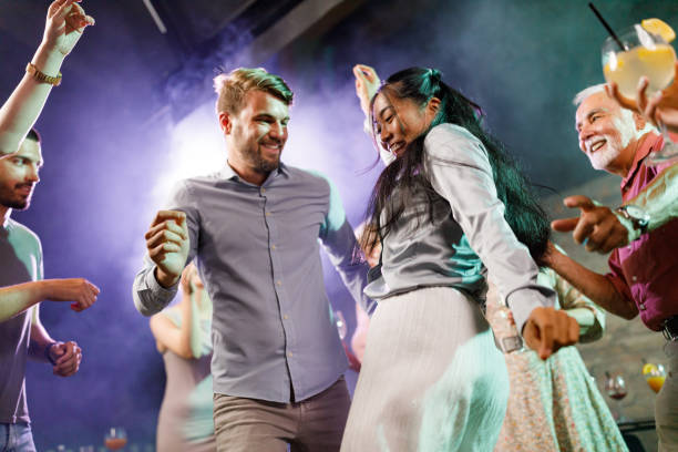 Below view of happy couple dancing during night out in a disco.