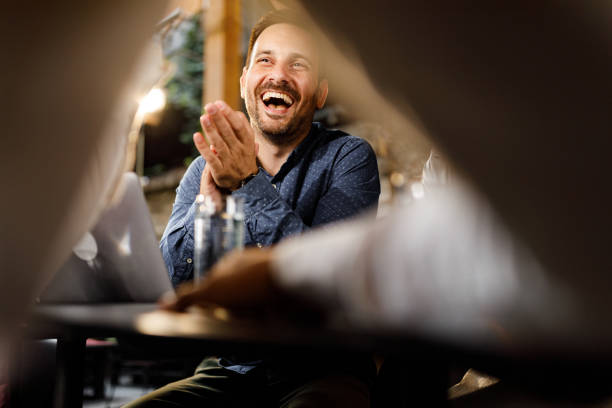 Cheerful businessman applauding in a cafe.