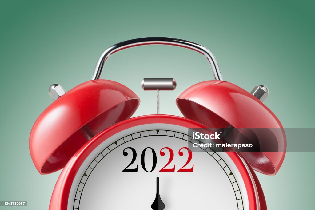 New Year 2022. Close up view of a red alarm clock. New Year 2022. Close up view of a red alarm clock isolated on white background. 2022 Stock Photo