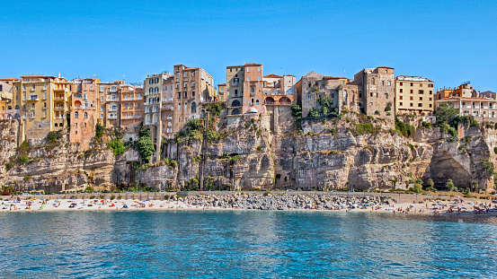 View of Tropea with a beach and people from the Tyrrhenian Sea.