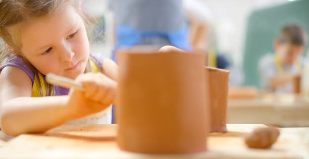 istock Girl making clay birdhouse 1343742224