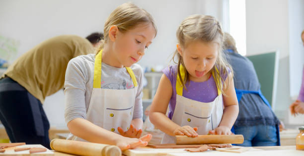 istock Girls rolling clay in classroom 1343742229