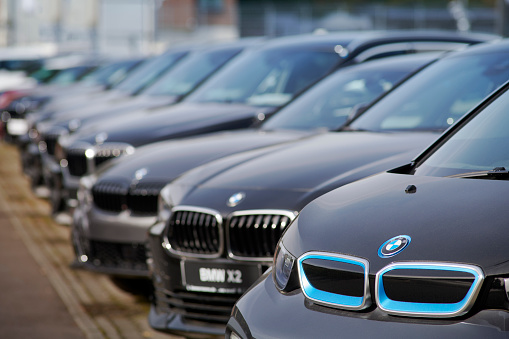 Neuss, Germany- Sept., 28, 2021: Row of new BMW cars in front of car dealer. The first car is an electric i3, the second a X2.