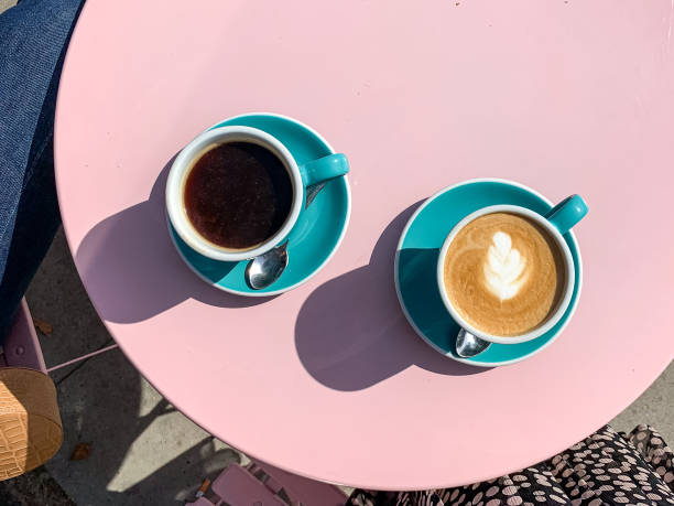 Morning coffees on pink table Morning coffees in tiffany color ceramic mugs with saucers on pink table. Black americano and latte. View from above coffe to stock pictures, royalty-free photos & images