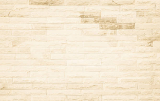 istock Empty background of wide cream brick wall texture. Beige old brown brick wall concrete or stone textured, wallpaper limestone abstract flooring/Grid uneven interior rock. Home decor design backdrop. 1343762798