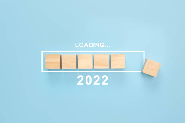 business concept of planning 2022. loading new year 2022 wood cube in progress bar. blue background - capital letter luxury blue image imagens e fotografias de stock