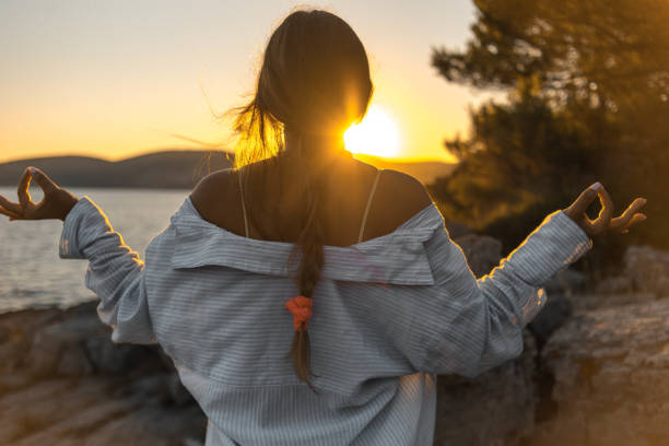 istock Young woman practicing yoga on the beach 1343770973
