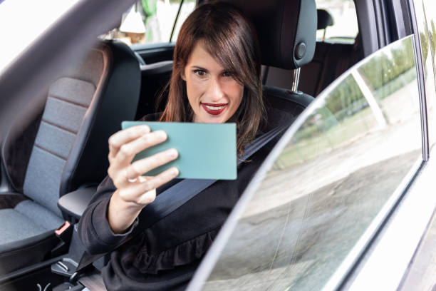 istock Distracted business woman looking herself in a mirror while driving a car. 1343771069