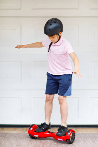 Active kid boy on hover board. Child driving modern balance hoverboard. Excercise and sports for children, outdoor activity for young kids.