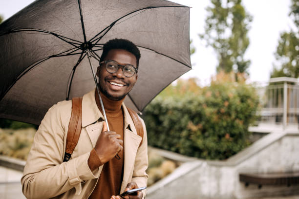 istock Young smiling businessman with umbrella 1343774274