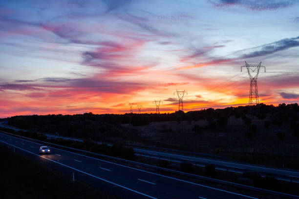 High Voltage Lines, along a highway at sunset.
