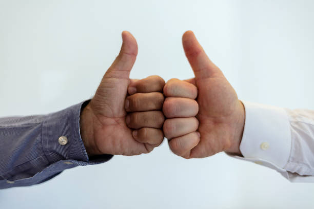 istock Two business people giving thumbs up in a modern office. 1343781467