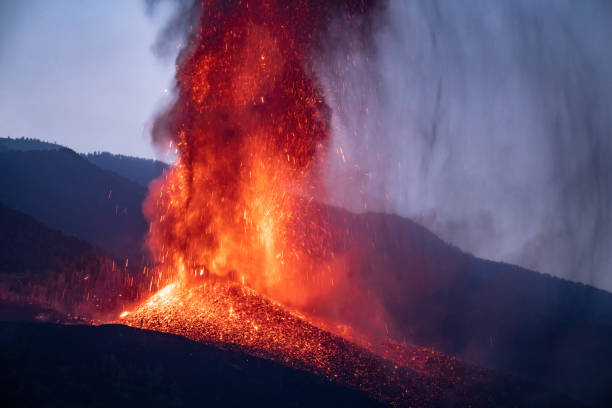 vulkanausbruch am abend in den bergen - eruption stock-fotos und bilder