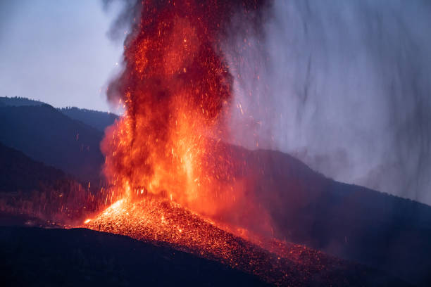 извержение вулкана вечером в горах - volcano erupting lava fire стоковые фото и изображения