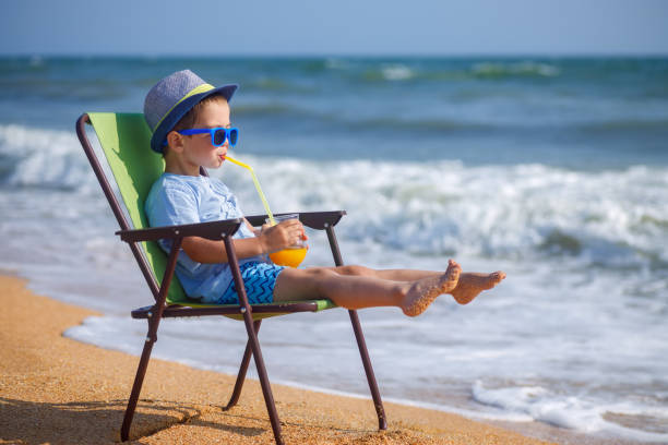 istock little boy drinking juice on sea beach 1343782001