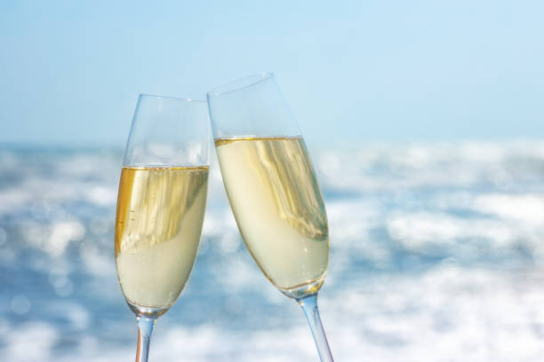 two glasses of champagne on the sea beach stock photo