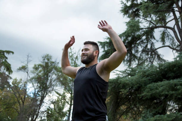 istock Young caucasian man with a beard practicing sport with his arms up outside a cloudy day 1343783101
