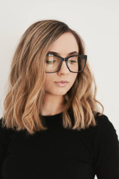 Portrait of a young blond woman with long bob haircut wearing eyeglasses with black frame. Eyewear. Vision and Eye care concept Portrait of a young blond woman with long bob haircut wearing eyeglasses with black frame. Eyewear. Vision and Eye care concept bobbed hair stock pictures, royalty-free photos & images