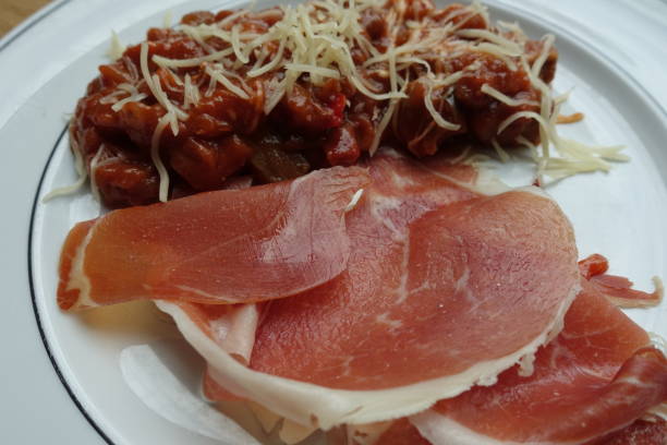 istock Raw ham served with an eggplant stew in a gratin tomato sauce 1343795637