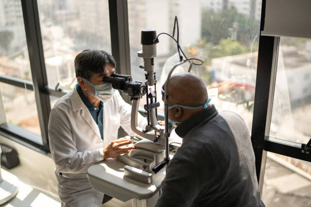istock Optometrist examining patient's eyes - wearing face mask 1343801887
