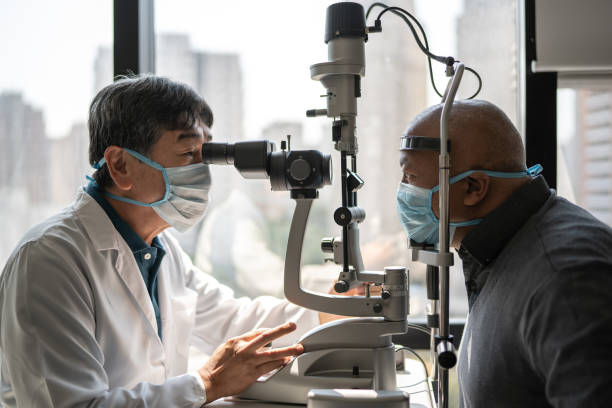 istock Optometrist examining patient's eyes - wearing face mask 1343801892